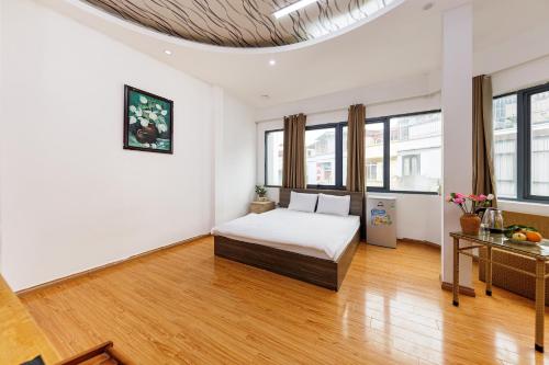 河内Lamaison Hà Nội的白色的客房配有一张床和一张桌子
