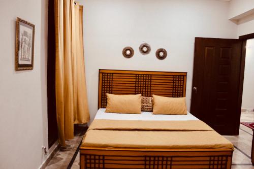 伊斯兰堡Islamabad Holiday Appartments One & Two Bed A Perfect Winter Escape to Murree, Northern Areas & Beyond的一间卧室配有一张大床和木制床头板