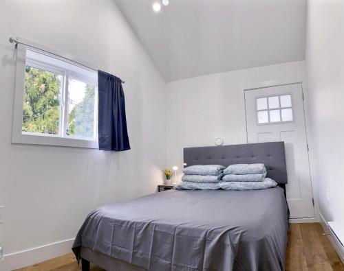 温哥华Vancouver’s Homey Laneway House的一间卧室配有带3个枕头的床