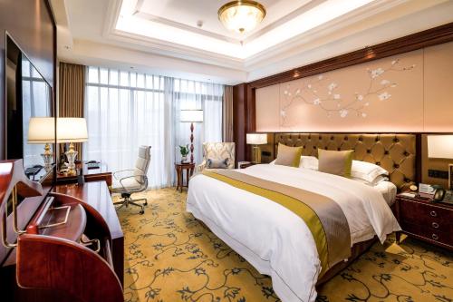 潍坊潍坊富华大酒店a座的酒店客房设有一张大床和一张书桌。