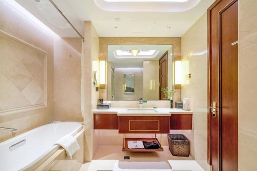 潍坊潍坊富华大酒店a座的带浴缸、水槽和镜子的浴室
