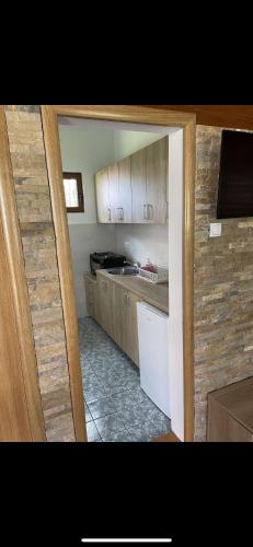 新瓦罗什Vikendica Car的厨房配有木制橱柜和白色冰箱。