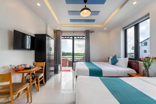 会安Rockmouse Centre River Villa Hoi An的酒店客房设有两张床、一张桌子和一张书桌。