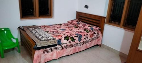 KānnangādVibgyor Home away from Home的一间卧室配有一张床和一把绿色椅子