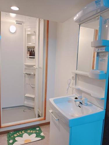 长崎ひまわりHotel的一间带水槽和冰箱的小浴室