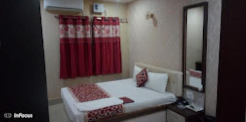 锡尔杰尔Hotel Holiday inn , Kanakpur的一间卧室配有红色的淋浴帘和一张床