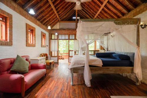 哲帕拉哈瑞曼尼斯小屋的一间卧室配有天蓬床和沙发