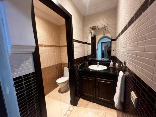 马拉喀什Magnifique, Appartement, familial, spacieux 2chambres salon salle à manger的一间带水槽、卫生间和镜子的浴室