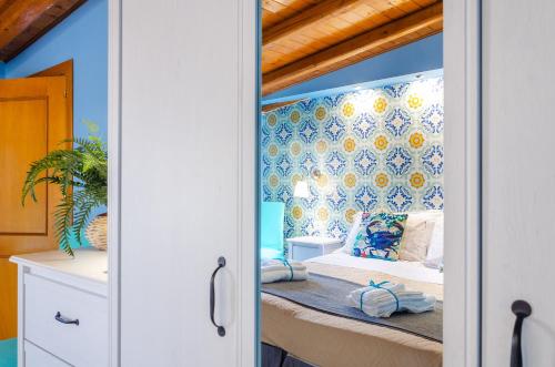 里波斯托Casa delle Zammare Fronte mare centro storico的一间卧室配有一张蓝色墙壁的床