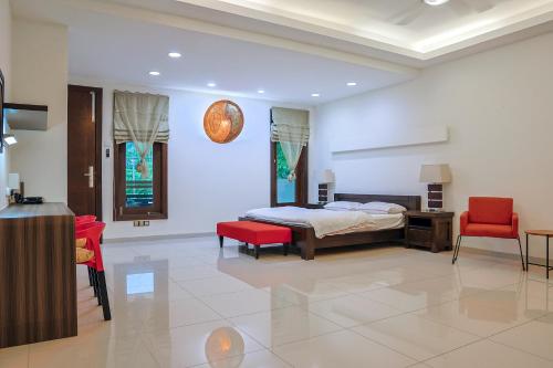 瓜埠Kuah Town - Villa Indah的一间卧室配有一张床和两张红色椅子