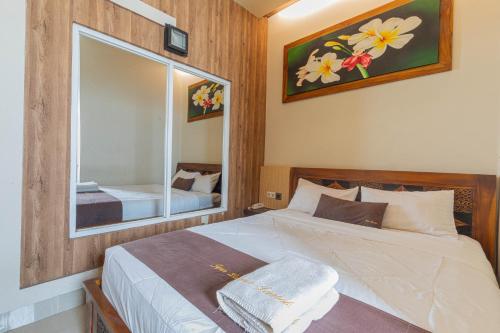 马塔兰Jepun Guest House的一间卧室配有一张大床和镜子