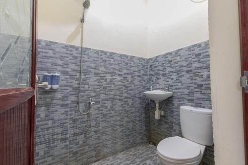 马塔兰Penginapan Asri的带淋浴、卫生间和盥洗盆的浴室