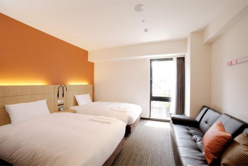 札幌札幌奈茨酒店的酒店客房,设有两张床和一张沙发