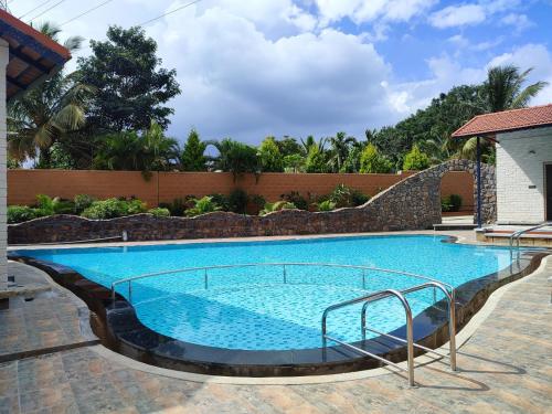 班加罗尔Nirvana Club Resort and Spa的蓝色海水大型游泳池