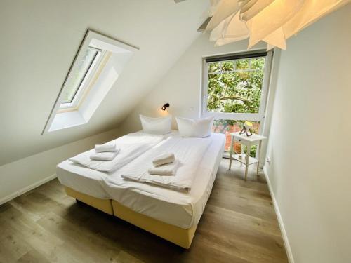 瓦尔内明德Sommerhaus am Bach的一间卧室配有一张带白色床单的床和一扇窗户。