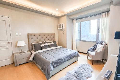 马尼拉Avant Spacious Sanctuary with the best view in BGC的卧室配有床、椅子和窗户。