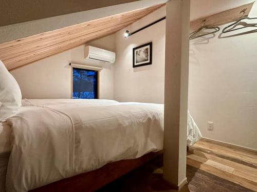 白马村The Misorano Cottage的卧室设有一张白色大床和一扇窗户。