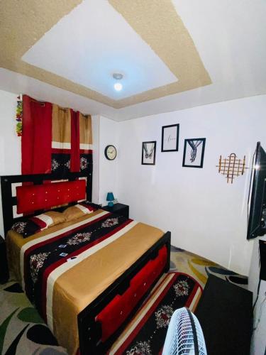 海地角Juju Boutique & House的一间卧室配有一张红色床头板的床