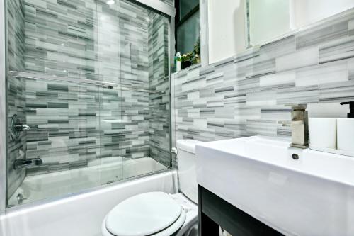 纽约Central & Cozy 2 BD APT In Manhattan的浴室配有卫生间、淋浴和盥洗盆。