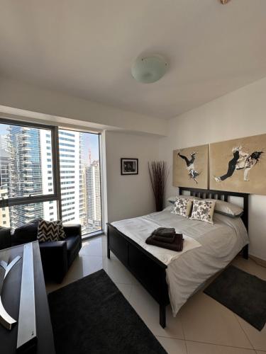 迪拜Amazing Double Room with En-suite, Marina and Sea views with shared kitchen的一间卧室设有一张床和一个大窗户