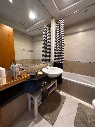迪拜Amazing Double Room with En-suite, Marina and Sea views with shared kitchen的浴室配有盥洗盆和浴缸。