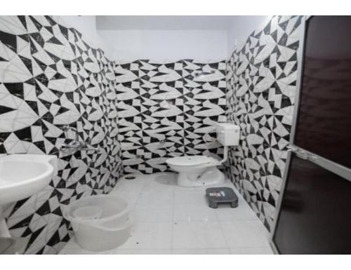 贾巴尔普尔Bisman Lodge, Jabalpur的浴室设有黑色和白色的瓷砖墙