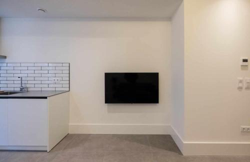 塞维利亚AT Presidente Nº1 apartamento privado completo的房间里的白色墙上的电视机