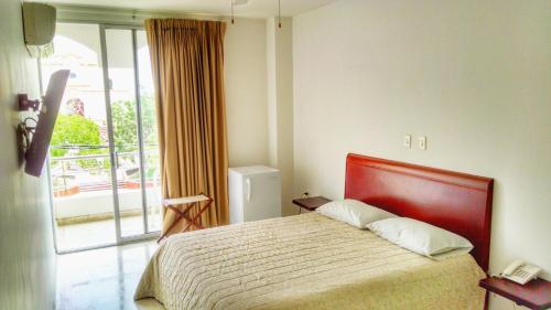 科罗萨尔Del Parque Hotel的酒店客房设有一张床和一个阳台。