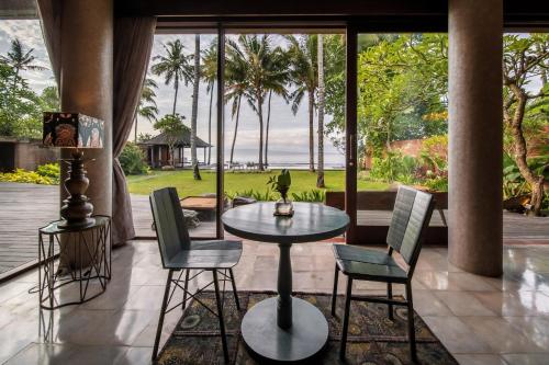 甘地达萨Villa Manis Beachfront Candidasa的一个带桌椅的海景庭院