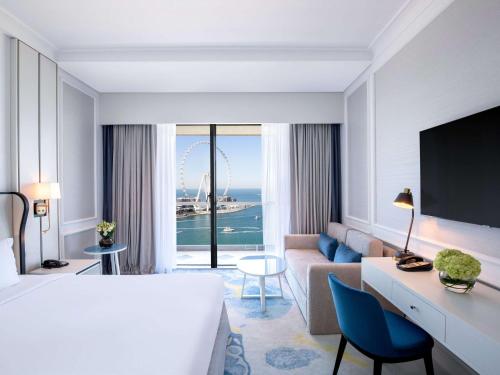 迪拜索菲特迪拜朱美拉海滩酒店的酒店客房设有一张大床和一张沙发。