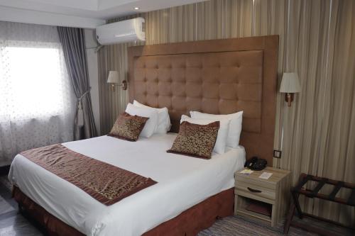 哈科特港Golden Tulip Hotel Port Harcourt -GTPH的一间位于酒店客房内的带大床的卧室