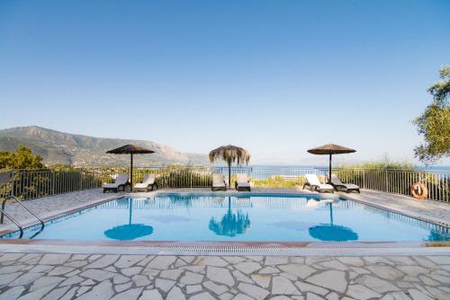 达西亚Giorgos apartments的一个带椅子和遮阳伞的游泳池