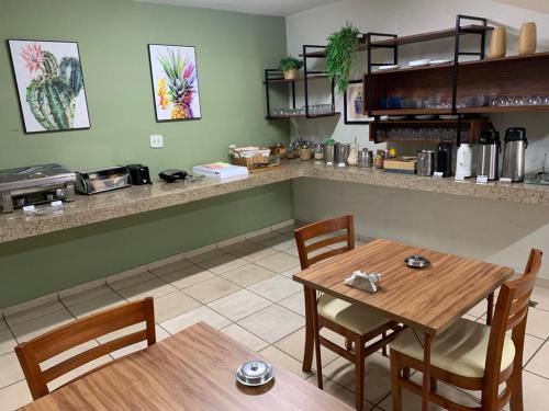 Três PontasHotel Ouro Verde的一间带2张桌子和柜台的用餐室
