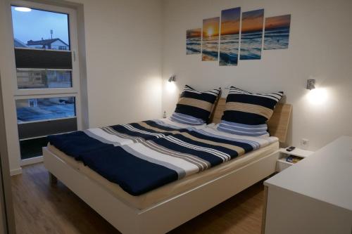 达默Dahmer Strand 16 Sonnenloge的一间卧室配有一张带蓝色和白色枕头的床