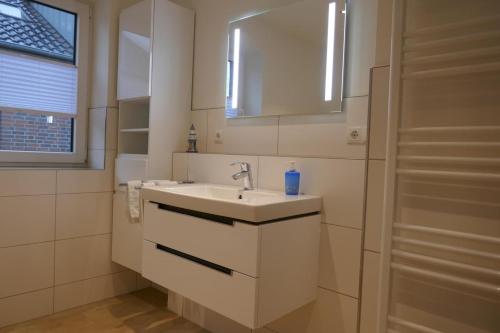 达默Dahmer Strand 16 Sonnenloge的白色的浴室设有水槽和镜子