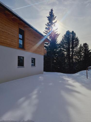 图拉彻霍赫My Turrach Grünsee Chalet by S4Y的房子旁边的雪地覆盖的院子