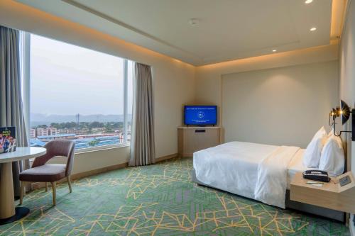 格德拉Holiday Inn Katra Vaishno Devi, an IHG Hotel的酒店客房设有一张床和一个大窗户