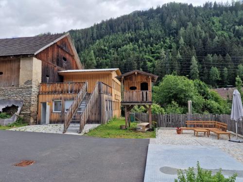 弗拉塔赫Gletscher-Trail Hostel的一座木结构建筑,设有木楼梯,毗邻一座房子