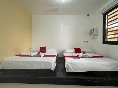 黎牙实比RedDoorz near Mariners Legazpi的配有白色床单和窗户的客房内的两张床