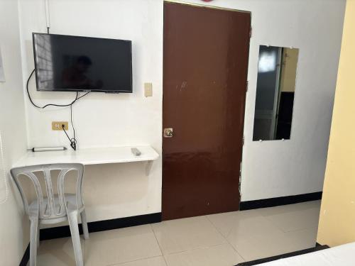 黎牙实比RedDoorz near Mariners Legazpi的一间房间,墙上有桌子和电视