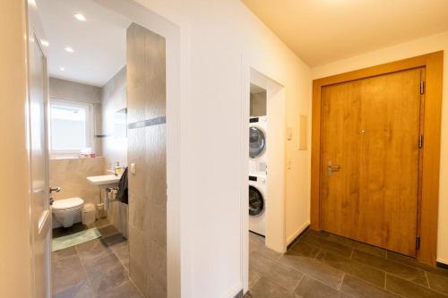 圣莫里茨Idyllic apartment in St. Moritz的浴室配有卫生间、盥洗盆和洗衣机。
