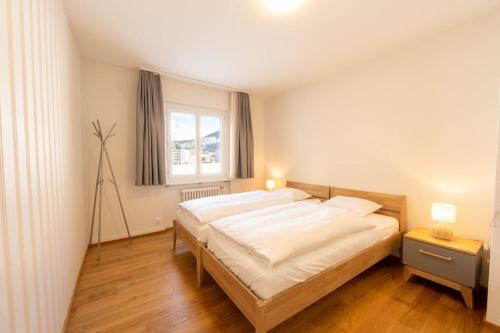 圣莫里茨Idyllic apartment in St. Moritz的一间卧室设有一张大床和一个窗户。