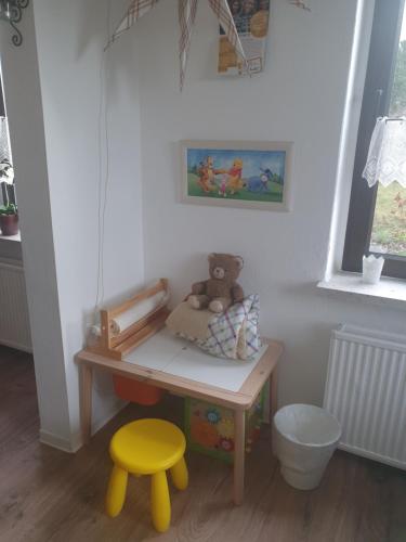 施内贝格Familienfreundliche Ferienwohnung Erzgebirge的玩具桌子,带泰迪熊和凳子