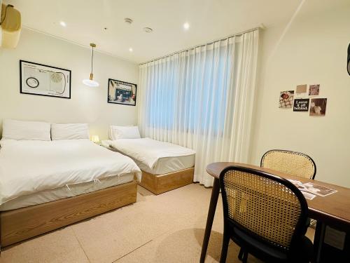 首尔SSH Ikseon peter cat Hostel的一间卧室配有两张床、一张桌子和一张书桌