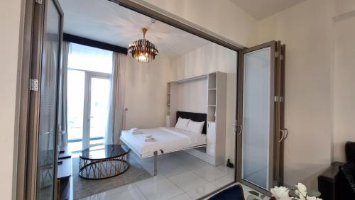 迪拜Spacious, Economical Apt Near Miralcz Garden的一间卧室设有一张床和一个玻璃门