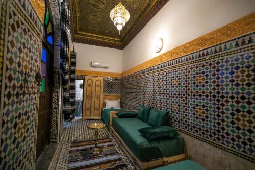 非斯Riad Fez Qamar的客厅配有绿色沙发和一些瓷砖
