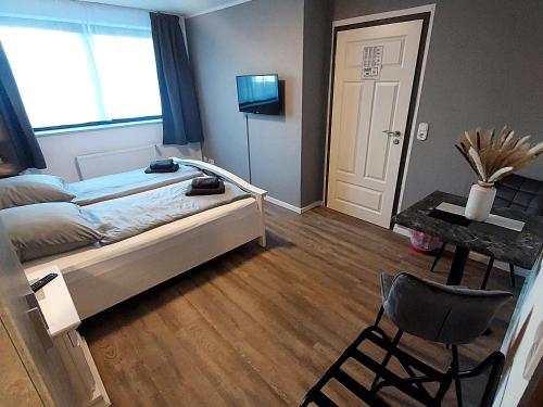 JagelLandgasthof "Hotel zum Norden"的卧室配有1张床、1张桌子和1把椅子