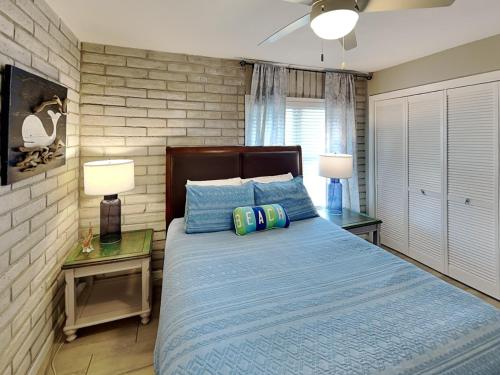 阿兰瑟斯港Pearl- Marlin的一间卧室配有一张蓝色的床、两张桌子和两盏灯。