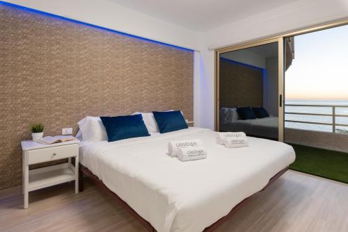 圣地亚哥港OBSIDIAN Mirador del Oceano的卧室配有带蓝色枕头的大型白色床