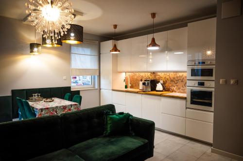 科希切日纳Apartament na Kaszubach的客厅配有沙发和餐桌,厨房配有桌子